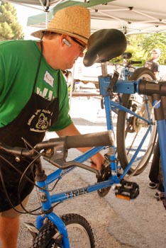Man in straw hat repairing blue bicycle